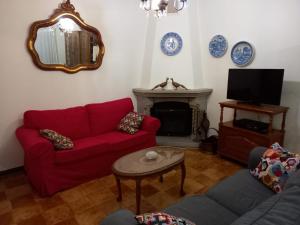 uma sala de estar com um sofá vermelho e uma lareira em Âncora Apartment em Vila Praia de Âncora