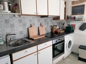 encimera de cocina con fregadero y lavavajillas en La Cayrade, en Uzer
