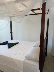 1 dormitorio con 1 cama con marco de madera en London Villa Secret Beach Mirissa, en Mirissa