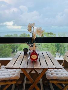 uma mesa de madeira com uma garrafa de vinho e flores em Alto da Barra *Ocean View em Oeiras