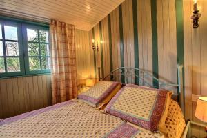 a bedroom with a bed and a window at Le petit moulin kersigalec in Canihuel