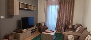uma sala de estar com um sofá e uma televisão em Appartement Cosy au calme em Ben Arous