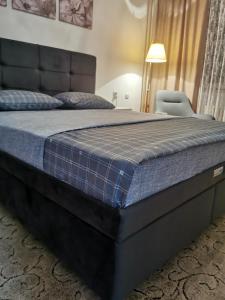 een groot bed in een slaapkamer met een blauw matras bij Apartman Aki in Pirot