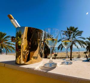 een fles wijn en drie wijnglazen op een tafel bij Mare e Castello in Manfredonia