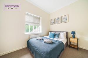 a bedroom with a bed with two stuffed animals on it at 2 Bedroom Apartment, Business & Contractors, FREE Parking & Netflix By REDWOOD STAYS in Basingstoke