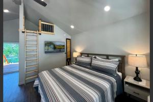 a bedroom with a bed and a ladder in it at Loft Cabin 3 - Rogue River Resort in Grants Pass
