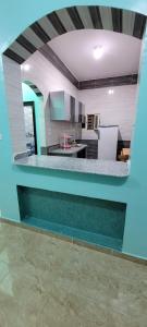 uma grande cozinha com paredes azuis e uma bancada em Ahmed House em Safaga