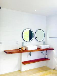 een badkamer met 2 wastafels en 2 spiegels bij Villa de 5 chambres avec vue sur la mer piscine privee et jardin clos a Le Carbet a 1 km de la plage in Le Carbet