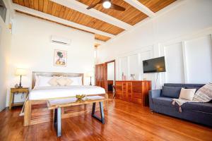 1 dormitorio con cama, sofá y mesa en Aruna Resort & Villas, en San Pedro
