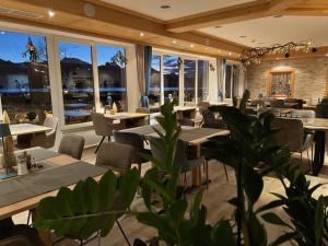 a restaurant with tables and chairs and windows at Hotel Fischer am See in Füssen