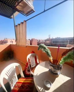 a table and chairs on a balcony with a potted plant at Nice apartment in the city center in Marrakech