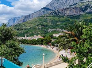 a beach with a bunch of people in the water at Vila Maslina Apartments mit Pool und Garten nahe am Strand in Tučepi