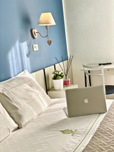 un computer portatile seduto sopra un letto di Hotel Alfa ALL INCLUSIVE 2024 a Rimini