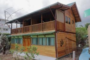a wooden house with a balcony on the side at Galapagos Chalet-Buda Chalet in Puerto Ayora