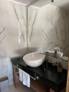 y baño con lavabo y espejo. en Excelente Depto Torre Leloir by Inside en Villa Marini