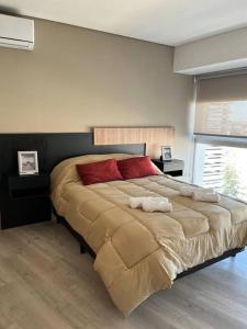 1 dormitorio con 1 cama grande con almohadas rojas en Excelente Depto Torre Leloir by Inside en Villa Marini