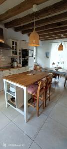 La belle de Ronsard في Chédigny: مطبخ مع طاولة وكراسي خشبية كبيرة
