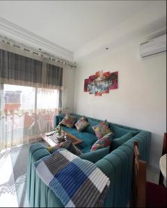 a person sitting on a blue couch in a living room at Nice apartment in the city center in Marrakech