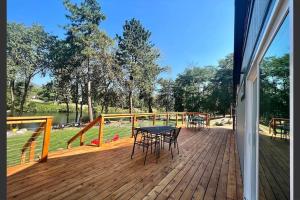 una terraza de madera con mesa y sillas. en Loft Cabin 4 - Rogue River Resort, en Grants Pass