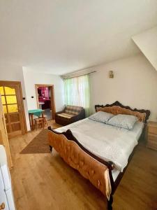 a bedroom with a large bed and a couch at Willa Maria in Kościelisko