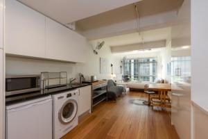 cocina y sala de estar con lavadora y secadora. en Central Studio in the Heart of Melbourne CBD!, en Melbourne