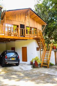 una casa con balcón y un coche aparcado delante en Casa Hostal Villa Del Rio, en El Zaino