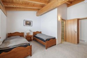 Habitación con 2 camas, paredes blancas y techos de madera. en Magnificent mountain home - 756, en Crans-Montana