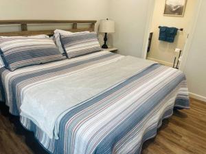 a large bed with a striped blanket in a bedroom at Deluxe Cabin 5 - Rogue River Resort in Grants Pass