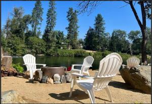 un gruppo di tre sedie seduti accanto a un lago di Deluxe Cabin 5 - Rogue River Resort a Grants Pass