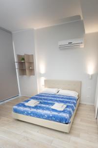 um quarto branco com uma cama com lençóis azuis em Monviso Mono - Exclusive Apartment em Milão