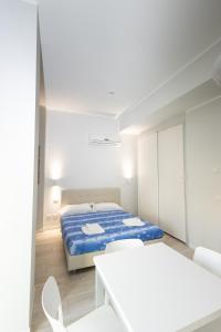 a white room with a bed and white chairs at Monviso Mono - Exclusive Apartment in Milan