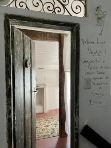 drzwi otwarte w pokoju z napisem na ścianie w obiekcie Apto com Arte no Pelourinho w mieście Salvador