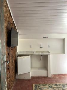 baño con lavabo y TV en la pared en Apto com Arte no Pelourinho en Salvador