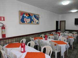 a room with tables and chairs and a painting on the wall at Pousada Belo Mar in Salvador