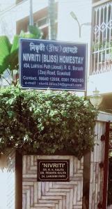 a sign on a building with a bush at Nivriti (Bliss) Homestay in Guwahati