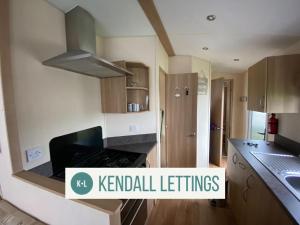 a kitchen with a sink and a stove top oven at Tebay (Green Lawns) in Selsey