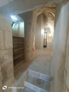 una habitación vacía con una pared de piedra y una escalera en La troglodyte fantastique Lochoise, en Loches