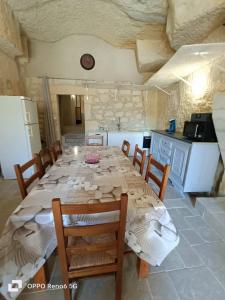 a dining room with a table and chairs in a kitchen at La troglodyte fantastique Lochoise in Loches