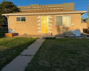 a house with a yellow door in the yard at 2 bedroom in Denver, Centralized in Denver