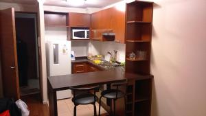 una pequeña cocina con encimera y taburetes. en Apartment Marin 80, en Santiago