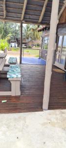 une terrasse en bois avec deux bancs au-dessus dans l'établissement Barra house, à Inhambane
