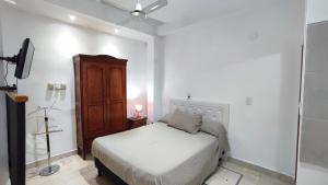 a white bedroom with a bed and a ceiling fan at Monoambiente temporario Banda in La Banda
