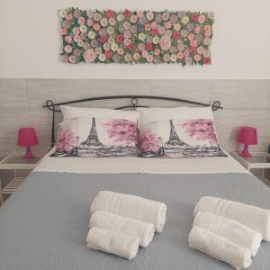 ein Bett mit zwei weißen Handtüchern mit dem Eiffelturm drauf in der Unterkunft Dimora Filangieri in Neapel
