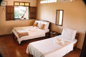 a hotel room with two beds and a window at Amazônia ParkSuítes in Novo Airão