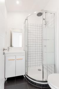 a white bathroom with a shower and a sink at Lapa Duplex Apartment in Lisbon