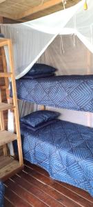 two bunk beds in a room with a ladder at Barra house in Inhambane