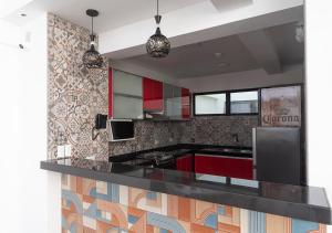 a kitchen with red cabinets and a black counter top at Hotel Precursores in Lima