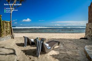 una sedia su una spiaggia con l'oceano sullo sfondo di Bubble Hotel Nyang Nyang - Adults only a Uluwatu