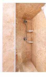 a shower with a shower head in a bathroom at Yellowknife Downtown 50a avenue Retreat in Yellowknife +7 photos