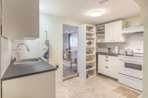 a kitchen with white cabinets and a sink at Yellowknife Downtown 50a avenue Retreat in Yellowknife